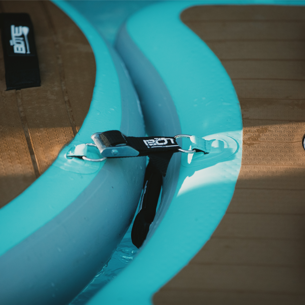 Close-up of BOTE DockLink II strap connecting two turquoise inflatable docks in water.