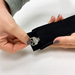 Key being inserted into hidden pocket of the BOTE coiled leash ankle strap.