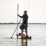 Man using sandspear to anchor himself on his Rackham Aero inflatable paddle board