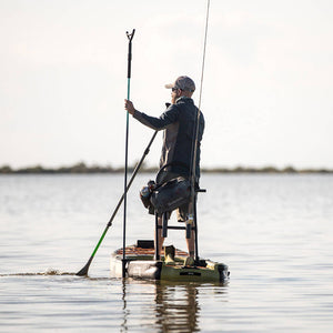 Man using sandspear to anchor himself on his Rackham Aero inflatable paddle board
