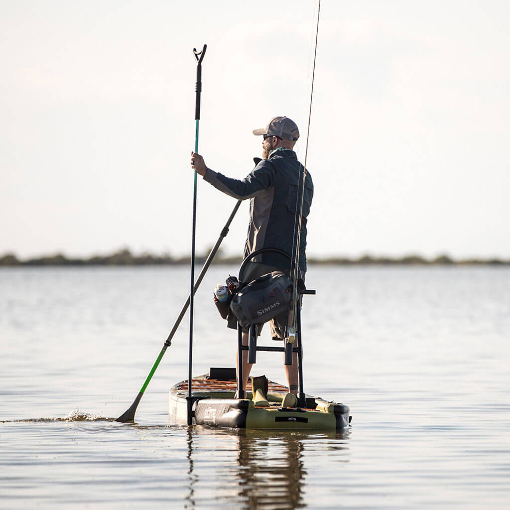 Man using sandspear to anchor himself on his Rackham Aero inflatable paddle board