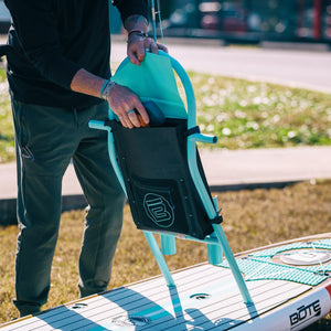 Close-up of a person loading gear into the Highwater Tackle Pouch Seafoam on a BOTE rack.