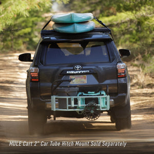 Car holding two boards on top while pulling Mule Cart on the back of the car